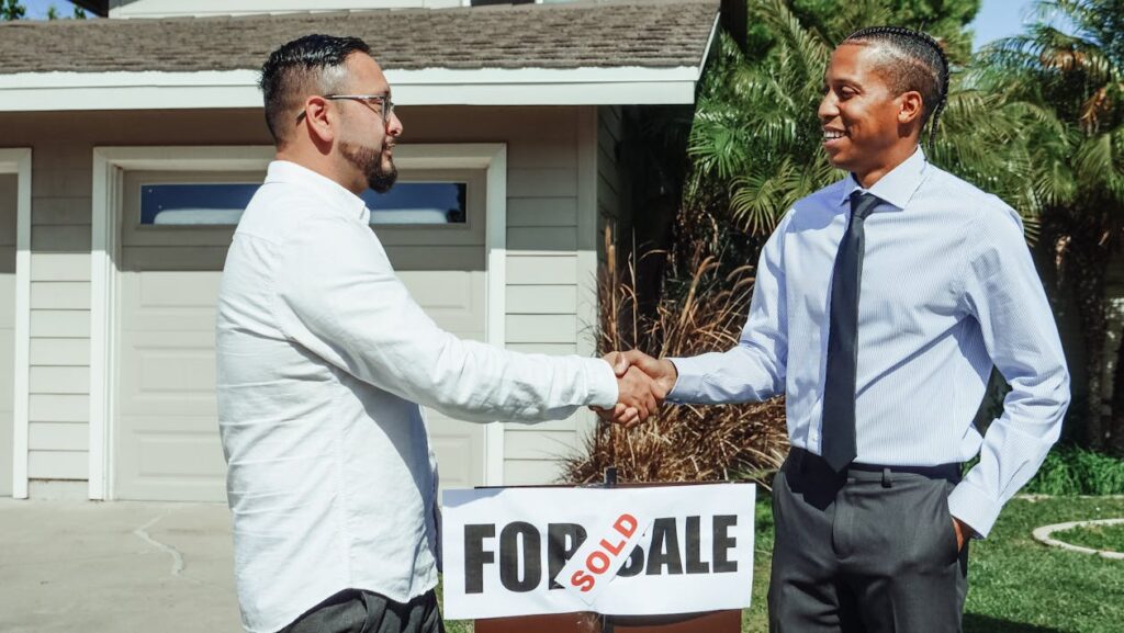 Home buyers shaking hands in front of a house, representing a mid-year property purchase
